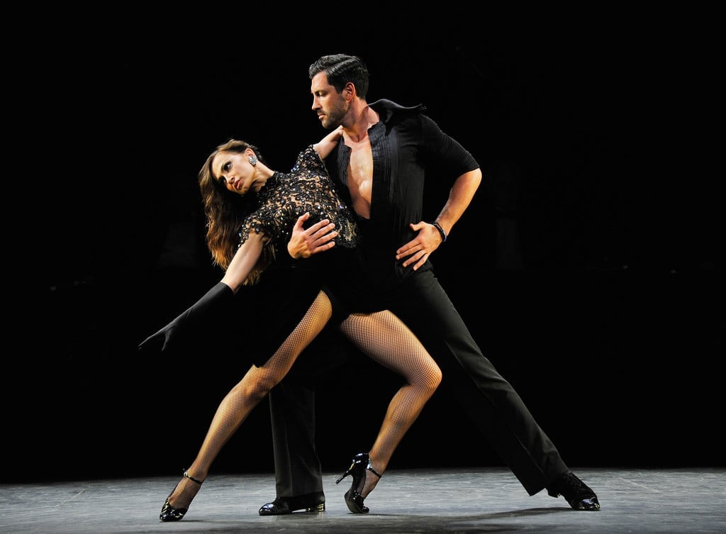 Plesni show nastupi – dramatičan tango na crnoj pozornici, žena u elegantnoj crnoj haljini nagnuta unatrag Plesna škola Banderillas Zagreb